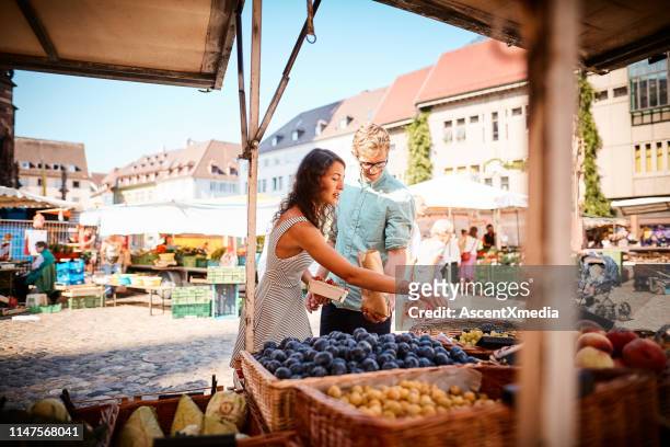 negozio di coppia al mercato della frutta estiva all'aperto - mercato di prodotti agricoli foto e immagini stock
