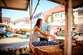Couple shop at outdoor summer fruit market