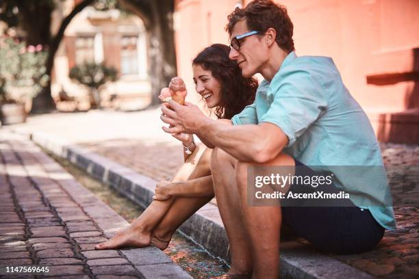 couple enjoy cultural food on a city promenade - shorts stock pictures, royalty-free photos & images