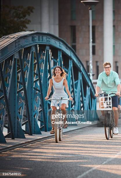 ehepaar lächelt, wenn sie entlang der brücke radeln - freiburg im breisgau stock-fotos und bilder