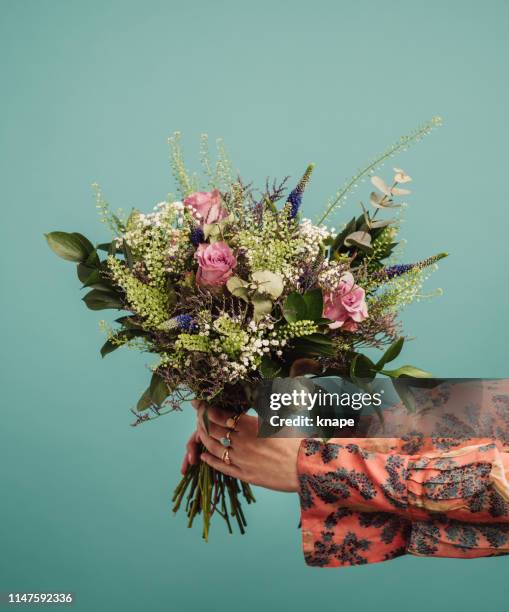 frau mit einem großen blumenstrauß - blumenstrauß stock-fotos und bilder