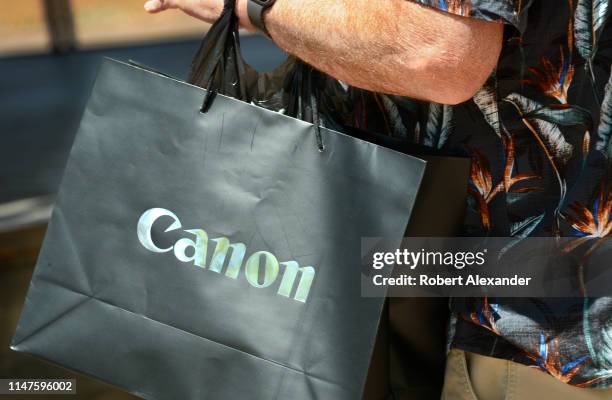 Man carries a Canon shopping bag in downtown Santa Fe, New Mexico.