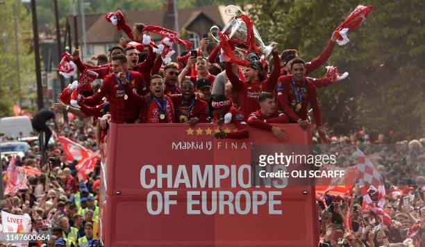 Liverpool's Spanish defender Alberto Moreno holds aloft the European Champion Clubs' Cup trophy as he stand with teammates Liverpool's English...