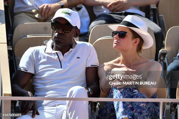 French actor Lucien Jean-Baptiste and French actress Aurelie Nollet look at a fourth round tennis match on the Philippe Chatrier court, on day eight...