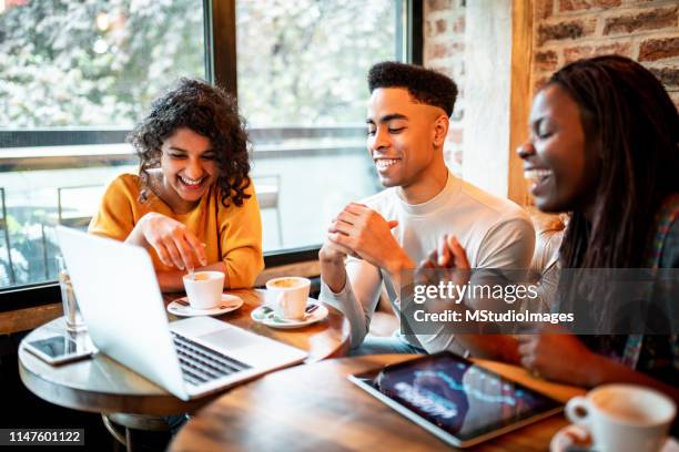Drie glimlachende millennials werken vanuit de bar.