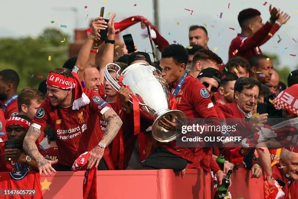 Liverpool's English defender Trent Alexander-Arnold kisses the European Champion Clubs' Cup trophy during an open-top bus parade around Liverpool,...