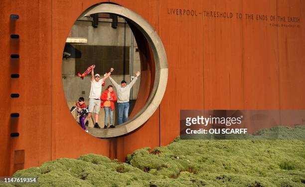 Football fans wait to see the Liverpool football team take part in an open-top bus parade around Liverpool, north-west England on June 2 after...