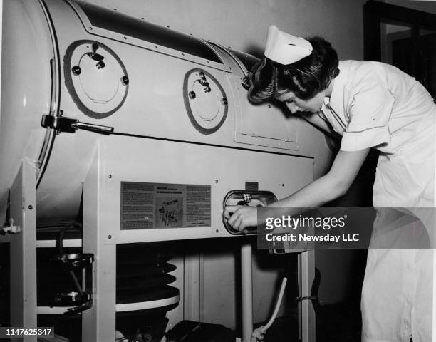 Sara Sheard, R.N., a staff nurse at Meadowbrook Hospital in East Meadow, New York, examines one of the three iron lungs brought to the facility to...