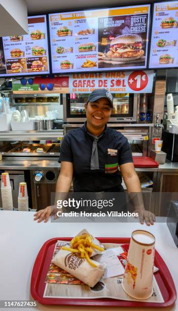 Staffer smiles while serving a chicken wrap menu at the Burger King fast food restaurant on Preciados street near Plaza del Sol on May 07, 2019 in...