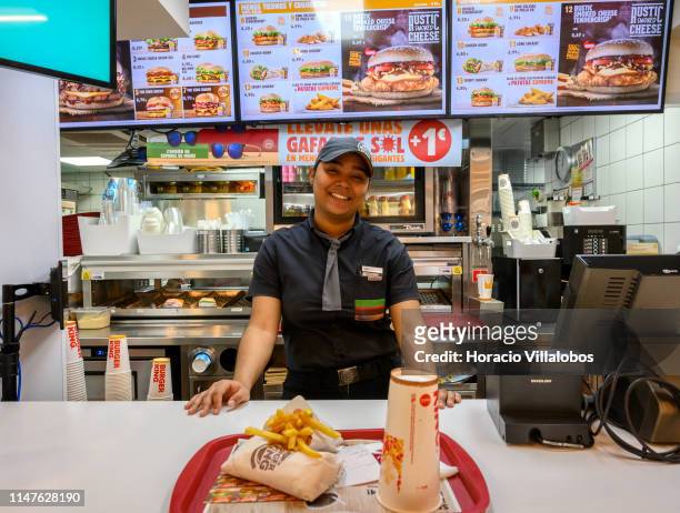 Staffer smiles while serving a chicken wrap menu at the Burger King fast food restaurant on Preciados street near Plaza del Sol on May 07, 2019 in...