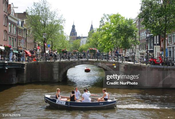 People enjoying in the boats at the Prinsengracht canal on June 2, 2019 in Amsterdam,Netherlands. Temperatures of 30 degrees Celcius were forecast in...