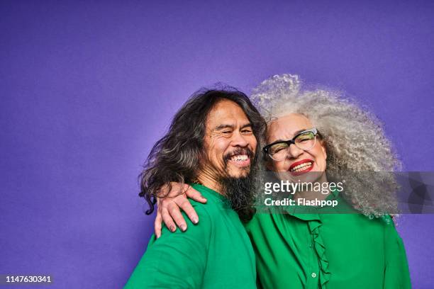 colourful studio portrait of a senior man and woman - couple sourire studio photos et images de collection