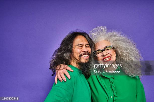 colourful studio portrait of a senior man and woman - senior studio portrait stockfoto's en -beelden