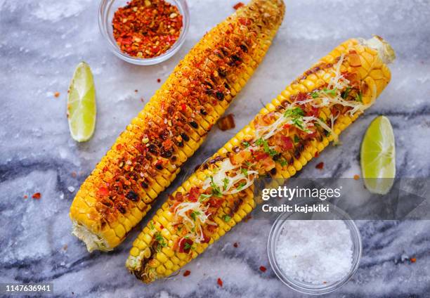 freshly grilled corn on the cobs with various toppings - corn cob stock pictures, royalty-free photos & images