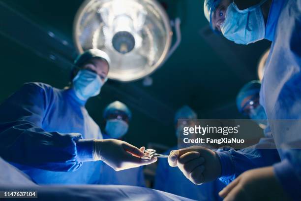 operating room staff performing hospital surgery - surgery stock pictures, royalty-free photos & images