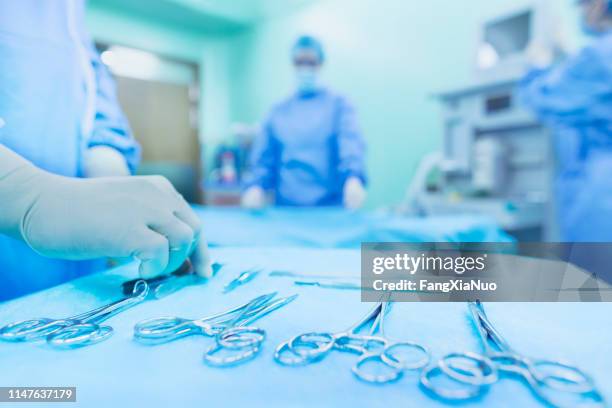 arranging surgical tools in operating room - equipamento cirúrgico imagens e fotografias de stock