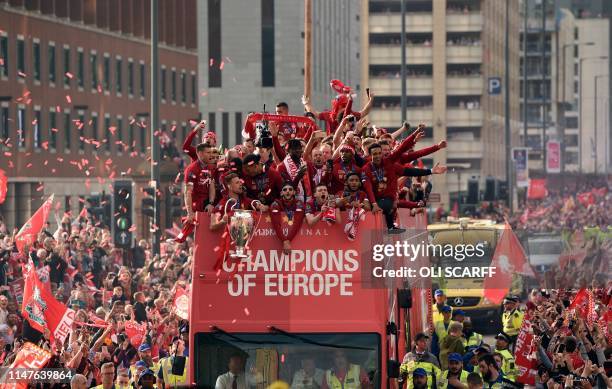 Liverpool's English midfielder Jordan Henderson holds the European Champion Clubs' Cup trophy during an open-top bus parade around Liverpool,...