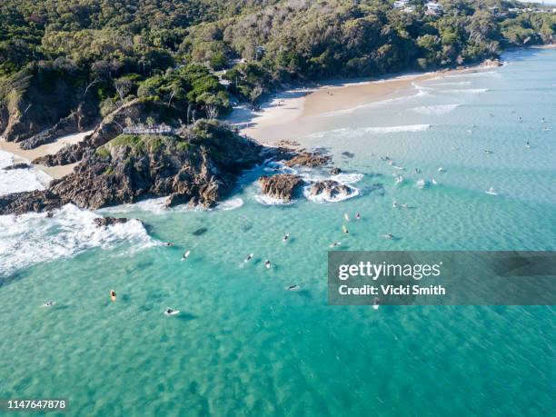 aerial viewpoint of surfers enjoying the ocean at byron bay australia - byron bay stock-fotos und bilder