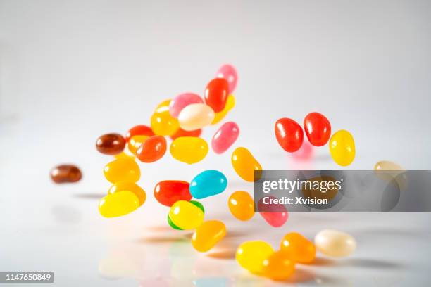 rainbow jelly bean candy jump in mid air captured with high speed sync - confiserie photos et images de collection