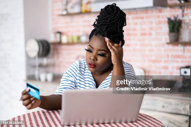 african woman using laptop and having problems with credit card - obsolete stock pictures, royalty-free photos & images