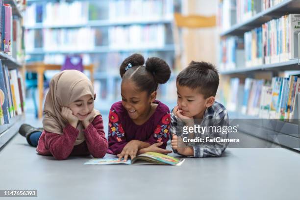 niños leyendo - reading fotografías e imágenes de stock