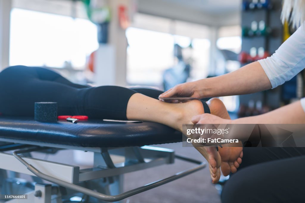 Physical therapist doing reflex work on a female's feet in a physiotherapy clinic