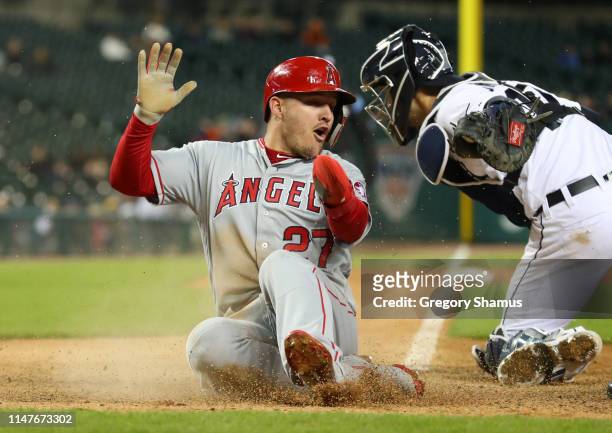 Mike Trout of the Los Angeles Angels slides past the tag of Grayson Greiner of the Detroit Tigers to score in the ninth inning at Comerica Park on...