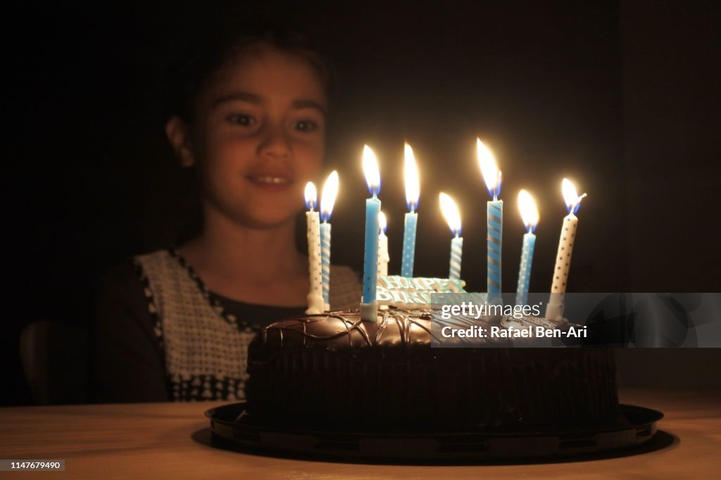 Young girl looking at  birthday part cake