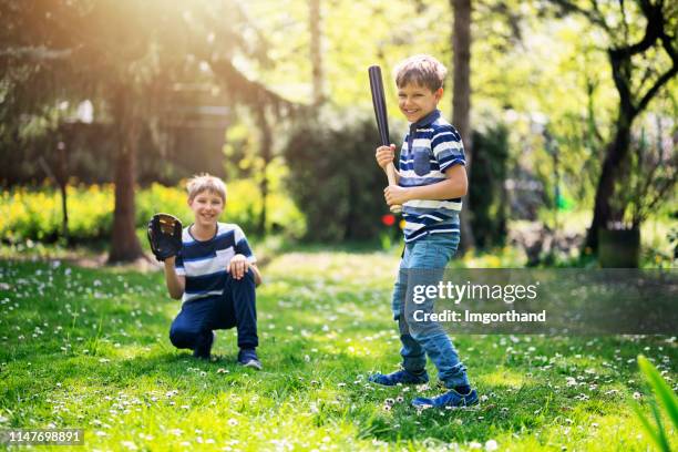 little boys playing baseball in the back yard - backyard baseball stock pictures, royalty-free photos & images