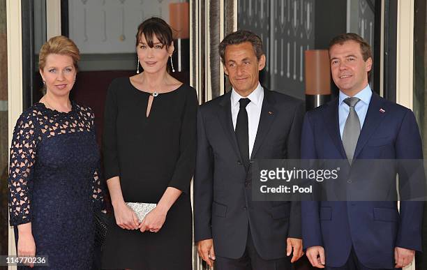 French President Nicolas Sarkozy and his pregnant wife Carla Bruni-Sarkozy greet Russian President Dmitry Medvedev and his wife Svetlana Medvedeva at...