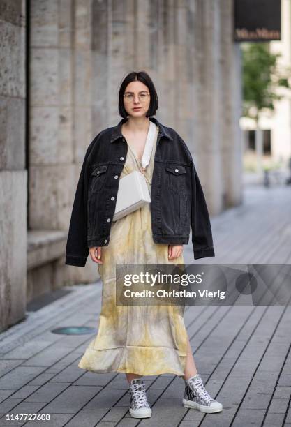 Maria Barteczko is seen wearing light yellow tie dye maxi dress Rabens Saloner, dark blue logo denim jacket Balenciaga, white crossboy baga Mutemuse,...