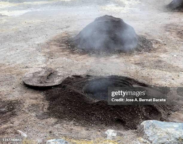 volcanic fumaroles with holes between the rocks issuing gases and very hot boiling water. island of sao miguel, azores islands, portugal. - cratera vulcânica imagens e fotografias de stock