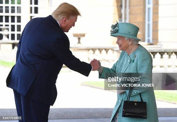 Britain's Queen Elizabeth II shakes hands with US President Donald Trump during a welcome ceremony at Buckingham Palace in central London on June 3...