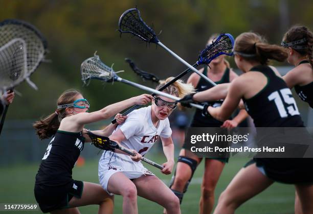 Tory McGrath of Cape Elizabeth spins through the Waynflete defense while attacking the goal in the second half. At left, defending is Emily Wagg of...