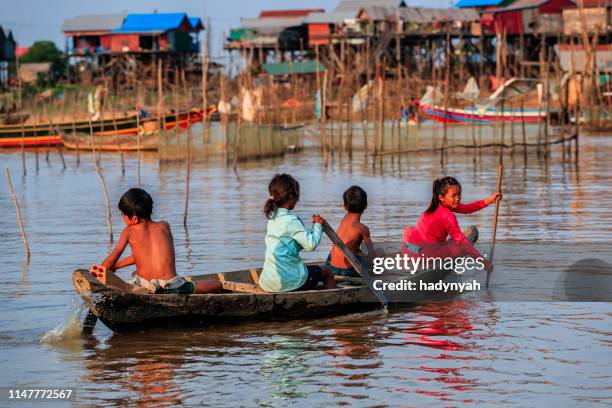group of happy cambodian children rowing a boat, tonle sap, cambodia - tonle sap stock pictures, royalty-free photos & images