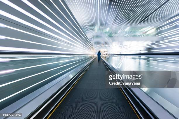 long horizontal escalator at international airport terminal - footpath stock pictures, royalty-free photos & images