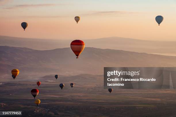 hot air balloons at sunrise in cappadocia - balão de ar quente - fotografias e filmes do acervo