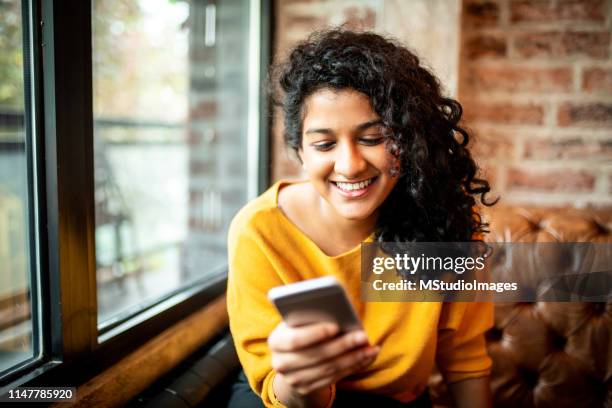 using mobile phone. - indian lady stock pictures, royalty-free photos & images