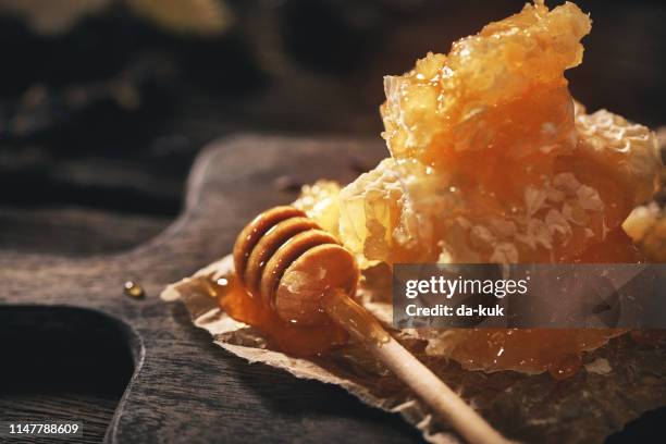 honeycomb and bamboo dipper on wooden table - favo de mel imagens e fotografias de stock