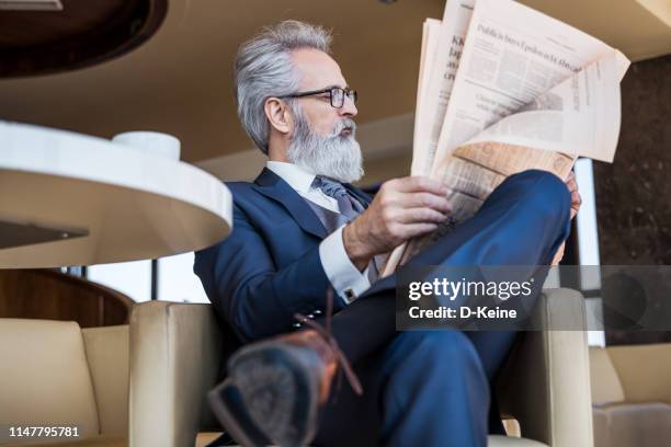 classy gekleidet senior geschäftsmann mit guter zeit kaffeehaus - newspaper luxury stock-fotos und bilder
