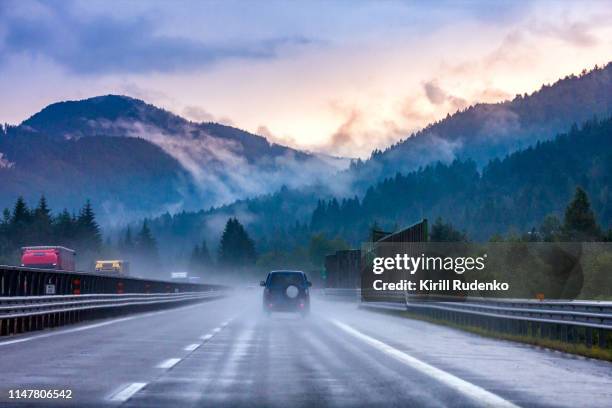 autostrada a23, a highway in italian alps on a summer evening during a heavy rainfall. - rainy road photos et images de collection