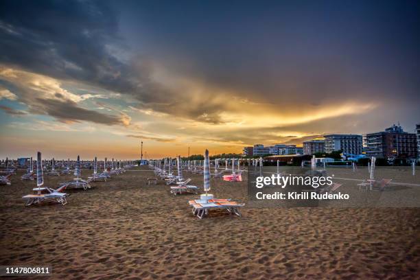 sun loungers on the beach in bibione on an evening before a thunderstorm - bibione stock pictures, royalty-free photos & images