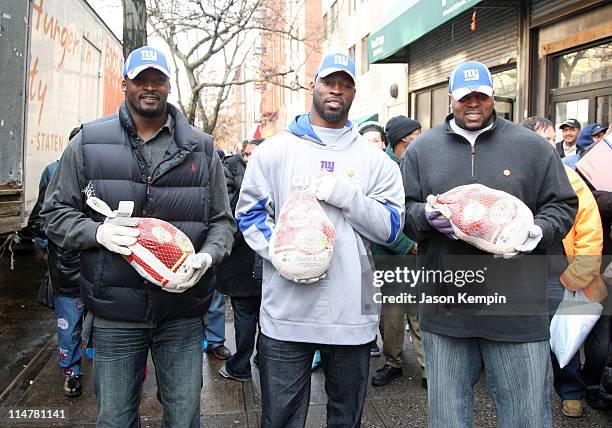Mathias Kiwanuka, Justin Tuck and Jeremy Clark of the New York Giants deliver Thanksgiving dinner to the Food Bank Community Kitchen of West Harlem...