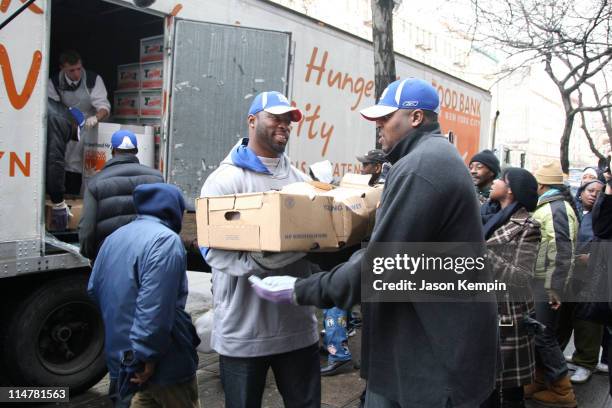 Mathias Kiwanuka, Justin Tuck and Jeremy Clark of the New York Giants deliver Thanksgiving dinner to the Food Bank Community Kitchen of West Harlem...
