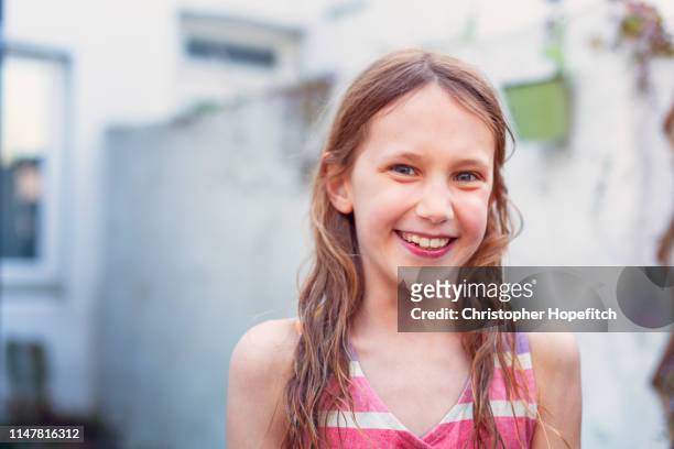 happy young girl in garden smiling at camera - only girls stock pictures, royalty-free photos & images