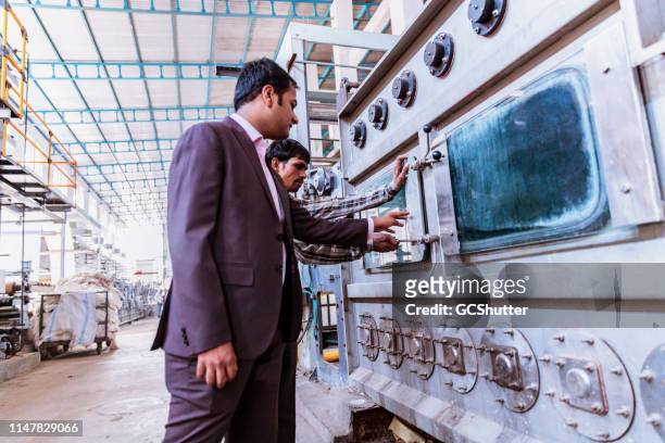 bedrijfseigenaar inspectie van de nieuw geïnstalleerde machines in de fabriek - mumbai colour stockfoto's en -beelden