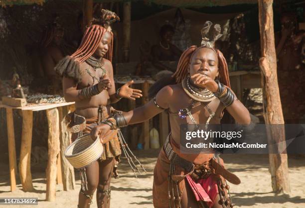 jonge himba vrouwen dansen in de voorkant van het dorp marktkraam - tribal dancing stockfoto's en -beelden