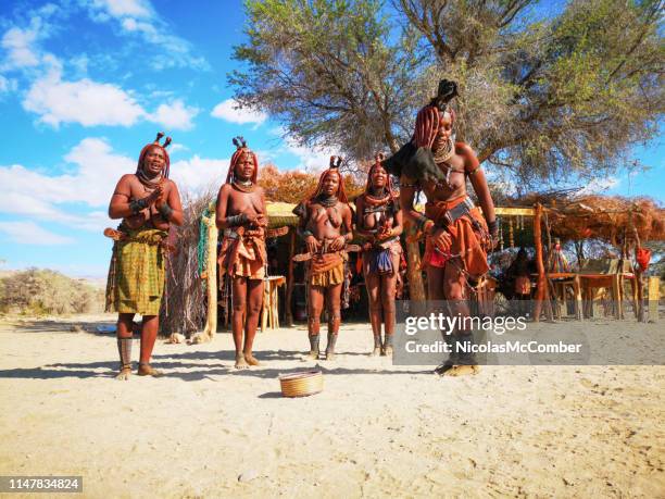 groep jonge himba vrouwen dansen in de voorkant van het dorp marktkraam - himba stockfoto's en -beelden