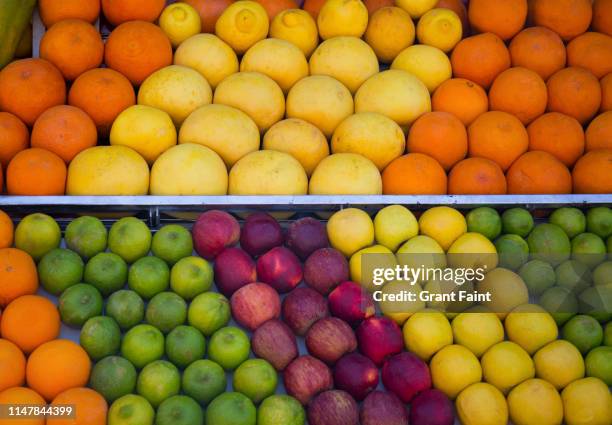 view of fruit stand in town square. - market stall stock pictures, royalty-free photos & images