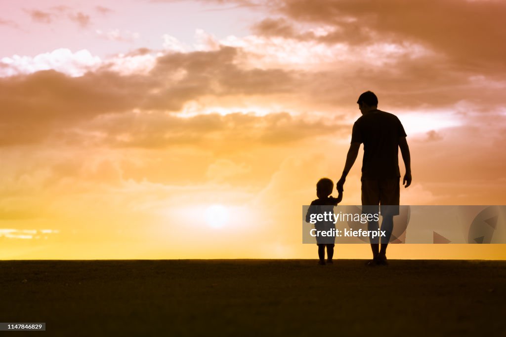 Father and son walking at sunset